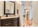 Elegant half-bathroom with granite countertop, dark vanity, and view into hallway at 1916 S Elati St, Denver, CO 80223