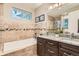 Luxurious bathroom featuring a soaking tub, granite countertops, and stylish tile work at 1916 S Elati St, Denver, CO 80223