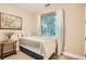 Comfortable bedroom with a bed, side table, and large window letting in ample natural light at 1916 S Elati St, Denver, CO 80223