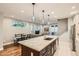Open-concept kitchen with a large island, pendant lights, and seamless flow into the living spaces at 1916 S Elati St, Denver, CO 80223