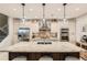 Modern kitchen featuring a large granite island, stainless steel appliances, and stylish pendant lighting at 1916 S Elati St, Denver, CO 80223