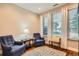 Bright living room featuring hardwood floors, large windows, and comfortable blue armchairs at 1916 S Elati St, Denver, CO 80223