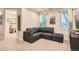 Cozy living room features comfortable sectional couch, natural light from two windows, and neutral paint at 1916 S Elati St, Denver, CO 80223