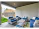 Relaxing covered patio features stylish outdoor furniture, a colorful rug, and a view of the backyard at 1916 S Elati St, Denver, CO 80223