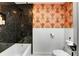 Well-lit bathroom featuring a unique patterned wallpaper and updated fixtures at 3885 Hoyt St, Wheat Ridge, CO 80033