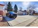 View of the home's 3-car garage, driveway, and landscaping at 3885 Hoyt St, Wheat Ridge, CO 80033