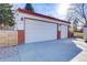 Three car garage with painted doors and red brick accents at 3885 Hoyt St, Wheat Ridge, CO 80033