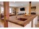 Modern kitchen area with a walnut countertop, copper sink, and a view into the spacious living room at 3885 Hoyt St, Wheat Ridge, CO 80033
