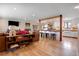 Open-concept living space featuring hardwood floors and seamless flow into the kitchen area with bar seating at 3885 Hoyt St, Wheat Ridge, CO 80033