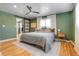 Spacious main bedroom featuring wood floors, a ceiling fan, and a sliding barn door to the closet at 3885 Hoyt St, Wheat Ridge, CO 80033