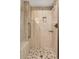 Tiled shower features a pebble floor, built-in seat and shower caddy at 3885 Hoyt St, Wheat Ridge, CO 80033