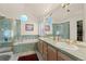 Bathroom with dual sinks, shower, tub, and round windows at 1011 S Valentia St # 121, Denver, CO 80247