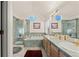 Stylish bathroom featuring dual sinks, tub, tiled shower, and plenty of natural light at 1011 S Valentia St # 121, Denver, CO 80247
