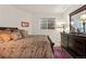 Bedroom featuring a dark wooden dresser and patterned bedding with natural light from the window at 1011 S Valentia St # 121, Denver, CO 80247