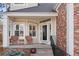 Inviting front porch with cozy seating, decorative shrubbery, and brick facade entrance for welcoming guests at 1011 S Valentia St # 121, Denver, CO 80247