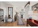 Hallway with wood floors, high ceilings, and large mirror, leading to open living spaces at 1011 S Valentia St # 121, Denver, CO 80247