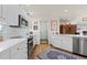 Bright, clean kitchen with stainless steel appliances, white cabinets, and hardwood floors at 1011 S Valentia St # 121, Denver, CO 80247