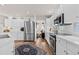 Spacious kitchen featuring white cabinets, stainless steel appliances, and hardwood floors at 1011 S Valentia St # 121, Denver, CO 80247