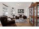 Cozy living room with hardwood floors, brown leather sofa, decorative area rug, and a custom curio cabinet at 1011 S Valentia St # 121, Denver, CO 80247