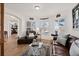 Bright living room featuring hardwood floors, plantation shutters, and a comfortable leather sofa and armchair at 1011 S Valentia St # 121, Denver, CO 80247