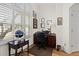 Bright home office with hardwood floors, dark wood furnishings, and natural light from a large window with shutters at 1011 S Valentia St # 121, Denver, CO 80247