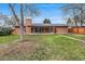 Spacious backyard with lush green grass, mature trees, and a covered patio at 2203 S Harlan St, Denver, CO 80227