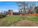 Expansive backyard featuring green grass, brick house, patio, and mature trees at 2203 S Harlan St, Denver, CO 80227