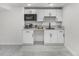 Basement bar with granite counters, microwave and white cabinets offer extra space to entertain guests at 2203 S Harlan St, Denver, CO 80227