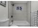 Neat bathroom showcasing modern gray tiles, a sleek bathtub, black hardware, and minimalist design at 2203 S Harlan St, Denver, CO 80227