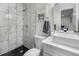 Modern bathroom with marble-style tile shower, black hexagon floor tiles, vessel sink, and contemporary fixtures at 2203 S Harlan St, Denver, CO 80227