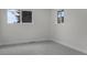Neutral bedroom with gray carpet, white walls, and natural light from two windows, creating a calm atmosphere at 2203 S Harlan St, Denver, CO 80227