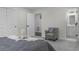 Bright bedroom featuring soft gray walls, plush gray carpet, modern furniture, and an ensuite bathroom entrance at 2203 S Harlan St, Denver, CO 80227