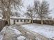 Home exterior view of fenced backyard with mature trees, lawn and concrete patio at 1780 Oswego St, Aurora, CO 80010