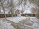 Fenced backyard with patio, a shed and snowy patches at 1780 Oswego St, Aurora, CO 80010