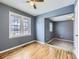 Sunlit bedroom with hardwood floors, bright blue walls, and large windows offering outdoor views at 1780 Oswego St, Aurora, CO 80010