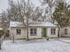 Charming single-story house with snow-covered lawn and a walkway to the green front door at 1780 Oswego St, Aurora, CO 80010