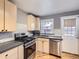 Well-lit kitchen with stainless steel appliances, bright wooden cabinets, and access to the backyard at 1780 Oswego St, Aurora, CO 80010