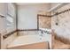 Modern bathroom featuring an oval soaking tub, decorative tilework, and a rain-style shower head at 8750 Redwing Ave, Littleton, CO 80126