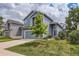 Two-story home with blue siding, well-manicured lawn, and attached garage showcases great curb appeal at 8750 Redwing Ave, Littleton, CO 80126