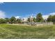 Community playground with play structures, swings, picnic area and white perimeter fence at 8750 Redwing Ave, Littleton, CO 80126