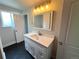 Updated bathroom with a modern vanity, stylish mirror and lighting at 15908 E Flora Pl, Aurora, CO 80013