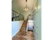 Inviting entryway featuring hardwood floors, staircase with black metal railing, and modern lighting at 15908 E Flora Pl, Aurora, CO 80013
