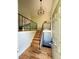 Inviting entryway featuring hardwood floors, staircase with black metal railing, and modern lighting at 15908 E Flora Pl, Aurora, CO 80013
