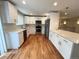 Modern kitchen with white cabinets, stainless steel appliances, and hardwood floors at 15908 E Flora Pl, Aurora, CO 80013