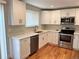 Well-lit kitchen featuring stainless steel appliances, white cabinetry, and quartz countertops at 15908 E Flora Pl, Aurora, CO 80013