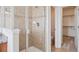 Tiled stand-up shower with glass door and view of toilet and walk-in closet at 8962 E Otero Pl, Centennial, CO 80112