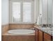 A tiled bathtub with windows provides natural light in this bathroom at 8962 E Otero Pl, Centennial, CO 80112