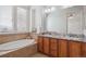 Bright bathroom featuring a soaking tub and double vanity with granite countertops at 8962 E Otero Pl, Centennial, CO 80112