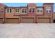 Townhome exterior with multi-car garages, brick and siding facade, and driveways at 8962 E Otero Pl, Centennial, CO 80112