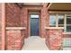 Charming brick townhouse featuring a modern front door and exterior lighting at 8962 E Otero Pl, Centennial, CO 80112